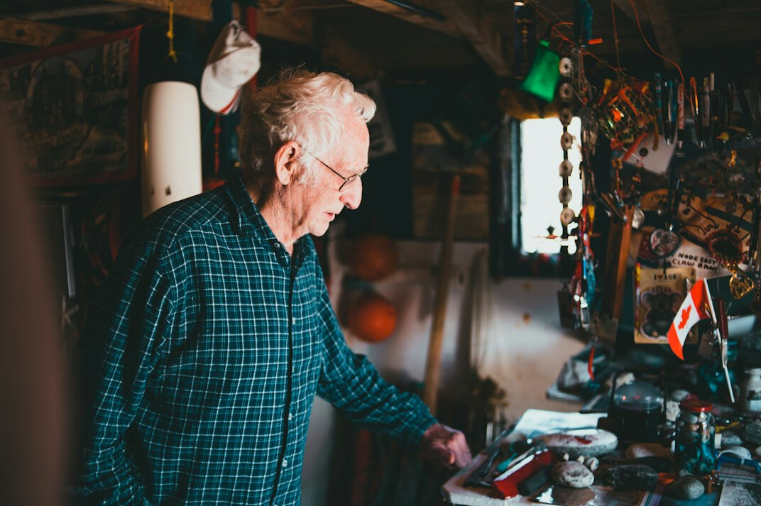 Senior man using a laptop to book an appointment online at a desk