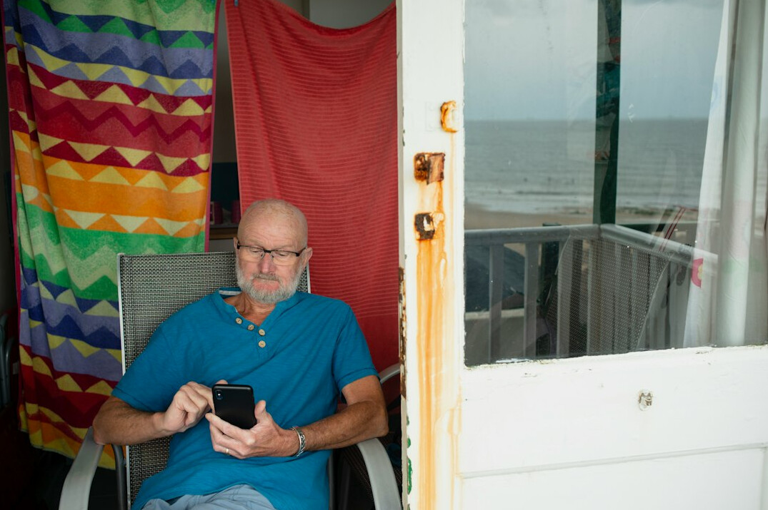 Senior man having a video call on a tablet at a kitchen table